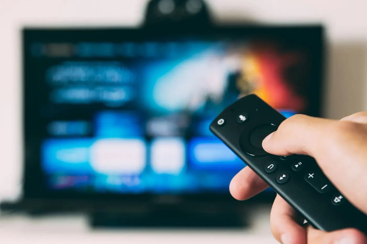 Hand met een afstandsbediening voor een tv met een streaming-app, klaar voor Nero IPTV
